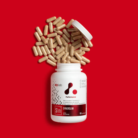 SynerSlim by ATP Lab container with open lid and scattered capsules on a red background